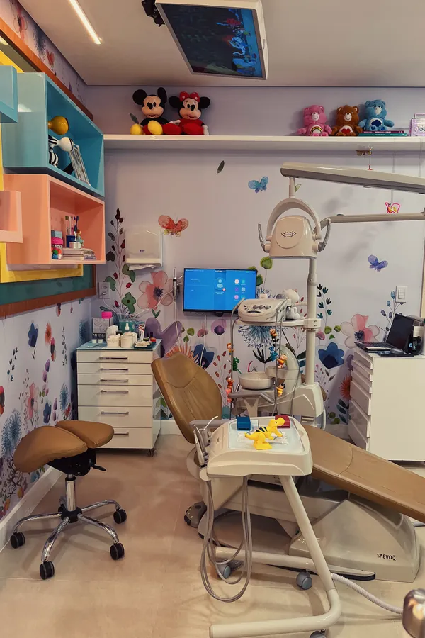Consultório de odontopediatria da Paiva Odonto, decorado para crianças com papel de parede de flores e bichinhos de pelúcia