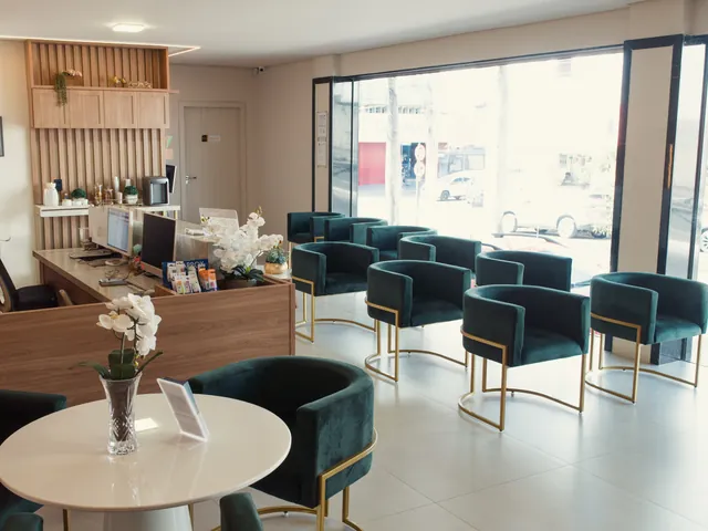 Sala de espera da Paiva Odonto com poltronas de veludo verde ao lado da recepção